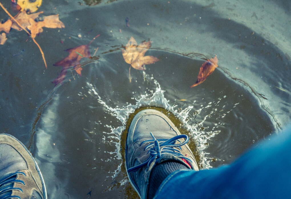 man dipping his fishing shoes in the water